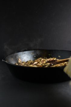 a wok filled with food sitting on top of a counter