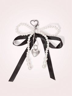 a bow with pearls and a heart hanging from it