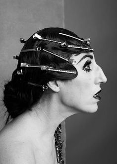 a woman with hair pins in her hair and wearing a headpiece that has spikes on it