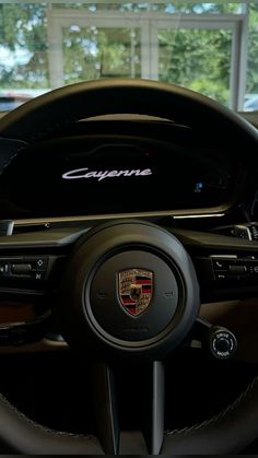 the steering wheel and dashboard of a porsche cayenne car in a showroom