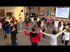 a group of children dancing in a classroom