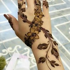 a woman's hand is decorated with hennap and flower designs on it