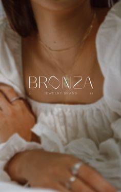 a woman in a white dress is holding her hands on her chest and the words bronza