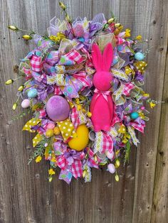 an easter wreath is hanging on a fence