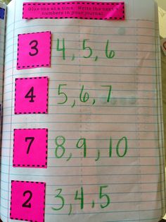 an open notebook with pink and green numbers on it