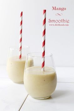 two glasses filled with smoothie sitting on top of a white counter next to each other