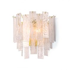 a glass and brass chandelier hanging from the ceiling on a white wall,