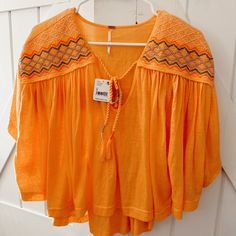 New With Tags Comfy And Flowy Blouse With Tassel Detailing Orange Floral Embroidered Top For Summer, Casual Orange Embroidered Blouse, Orange Embroidered Tops For Summer, Summer Embroidered Orange Blouse, Orange Embroidered Summer Blouse, Summer Orange Embroidered Blouse, Orange Embroidered Beach Top, Embroidered Orange V-neck Tops, Orange Embroidered V-neck Top