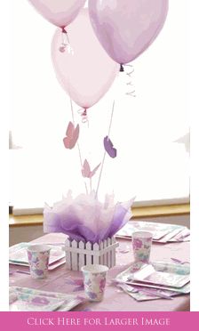 the table is set with pink and purple balloons, paper napkins, and cupcakes