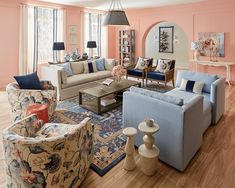 a living room filled with lots of furniture and walls painted pink, blue and white