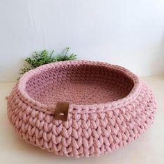 a pink knitted basket sitting on top of a table