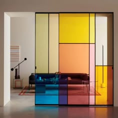 an image of a living room setting with colorful glass panels on the wall and couches