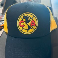 This Is An Outstanding Item For International Soccer Fans, A Brand New With Tags Club America Authentic Liga Mx Team Logo Trucker Hat, One Size Fits All. An Authentic Liga Mx Club America Hat, This Club America Authentic Liga Mx Team Logo Trucker Hat Features The Club America Team Logo Embroidered On The Front, Contrast Mesh Back Trucker Design With A Team Color Snapback Enclosure. If You Have Any Questions Regarding This Brand New With Tags Club America Authentic Liga Mx Team Logo Trucker Hat, Yellow Cap For Sports Events, Casual Yellow Baseball Cap For Sports Events, Casual Yellow Trucker Hat For Outdoor, Yellow Casual Baseball Cap For Sports Events, Yellow Flat Brim Trucker Hat For Outdoor, Casual Yellow Hat With Letter Print, Yellow Curved Brim Hats With Letter Print, Yellow Trucker Hat With Flat Brim For Streetwear, Yellow Hats With Letter Print And Curved Brim