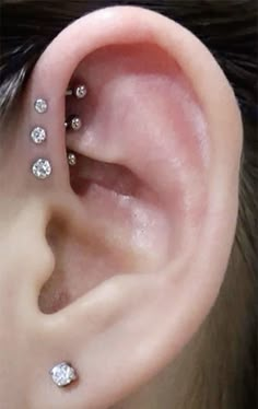 a woman's ear with three small diamonds on it