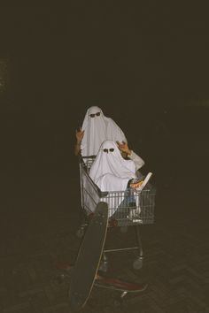 a person sitting in a shopping cart with a skateboard