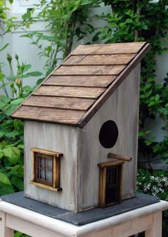 a bird house sitting on top of a wooden table