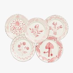 six pink and white plates with designs on them