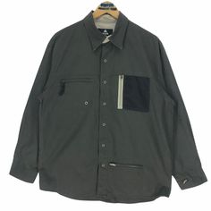 Vintage Airwalk button up shirt in military green colour. Button up cargo shirt. Still in good condition EXCEPT a broken zip on the top left pocket. SEE THE PICTURES FOR MORE DETAILS. CONDITION : 7.7/10 MEASUREMENT Pit : 23.5 inch Length : 30.5 inch Shoulder : 20.5 inch Arm Length : 23 inch Size On Tag : L Recommended Size : M-L PAYMENT We accept PayPal only. The item will be ship 3-5 days once the payment has been made. SHIPPING DHL ONLY. USUALLY AROUND 7-21 DAYS BEFORE REACH THE DESTINATION. * Military Tops With Pockets For Outdoor Activities, Collared Utility Shirt For Outdoor, Military Streetwear Shirt With Pockets, Military Style Streetwear Shirt With Pockets, Long Sleeve Shirt With Patch Pockets For Outdoor, Green Outdoor Shirt With Pockets, Button-up Tops With Pockets For Outdoor Activities, Green Shirt With Pockets For Outdoor Activities, Khaki Button-up Utility Jacket For Outdoor