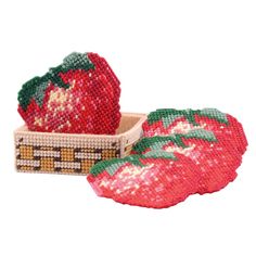 two red strawberries in a basket on a white background, one with green leaves and the other with pink flowers