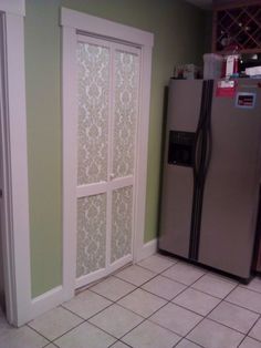 a refrigerator freezer sitting inside of a kitchen next to a tiled floor and walls