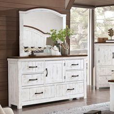 a white dresser and mirror in a room