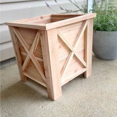 a wooden planter sitting on top of a carpeted floor next to a potted plant