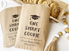 two bags with one smart cookie printed on them next to some cookies and tassels