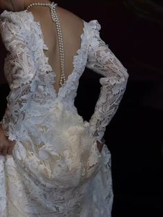 the back of a woman's wedding dress with pearls on her neck and shoulders