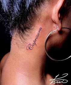 the back of a woman's neck with her name written on it, and a pair of hoop earrings