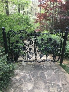 an iron gate in the middle of a garden