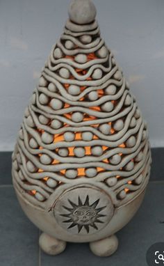 a white vase sitting on top of a tile floor next to a wall with an orange light in it