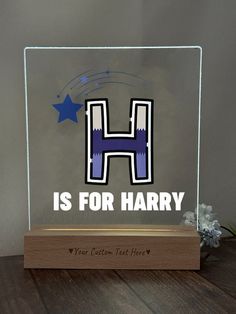 a glass block with the letter h is for harry on it, sitting on a table