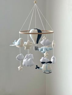 a crib mobile with clouds, hot air balloon and stars hanging from the ceiling