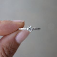 a person holding a diamond ring in their hand