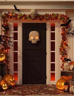 a front door decorated for halloween with pumpkins and skulls