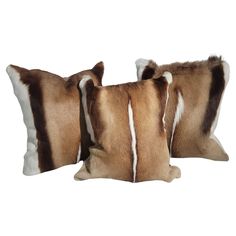 two brown and white striped pillows on a white background, one is made out of cow hide