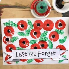 an art project with red poppies painted on paper and the words, let we forget