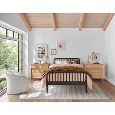 a bed room with a neatly made bed and two nightstands next to a window