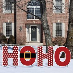 a large sign that says ho hoo in front of a brick building with snow on the ground