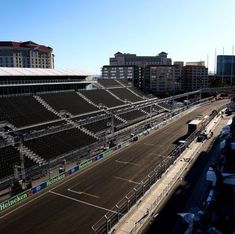 an empty race track in front of some buildings