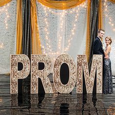 a bride and groom standing next to the word prom