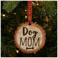 a wooden ornament hanging from a christmas tree with the word dog mom on it