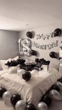 a bedroom decorated with balloons and black and white decorations for a birthday party or celebration