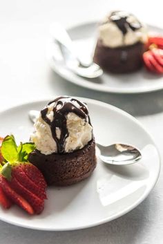 two white plates topped with dessert and strawberries