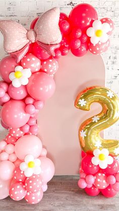 the number 2 is made out of balloons and heliums in pink, white, and gold colors