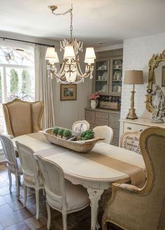 a dining room table with chairs and a basket on it's centerpiece in front of a window