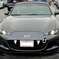 a black sports car parked on the side of the road with other cars behind it