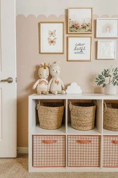 a white shelf with baskets and pictures on the wall next to a teddy bear in a basket