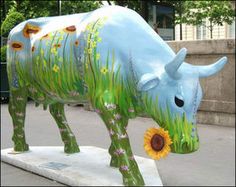 a statue of a cow with flowers painted on it