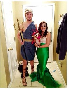 a man and woman dressed up as mermaids pose for a photo in the bathroom